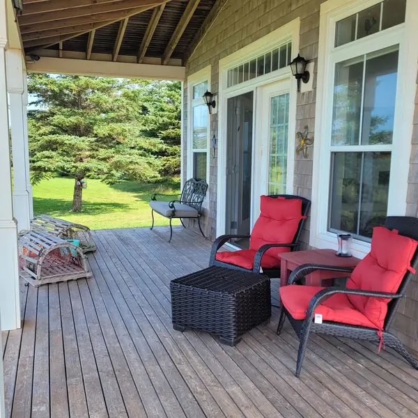 Red chairs on the covered porch in August