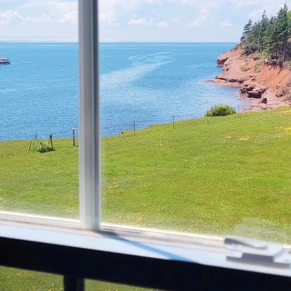 The lawn and the ocean through the common room window in June