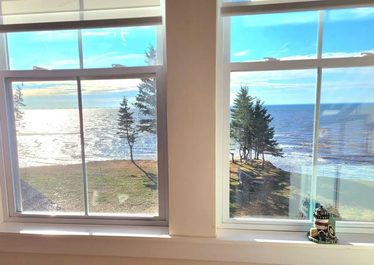 Corner guest room with two walls of windows over the water