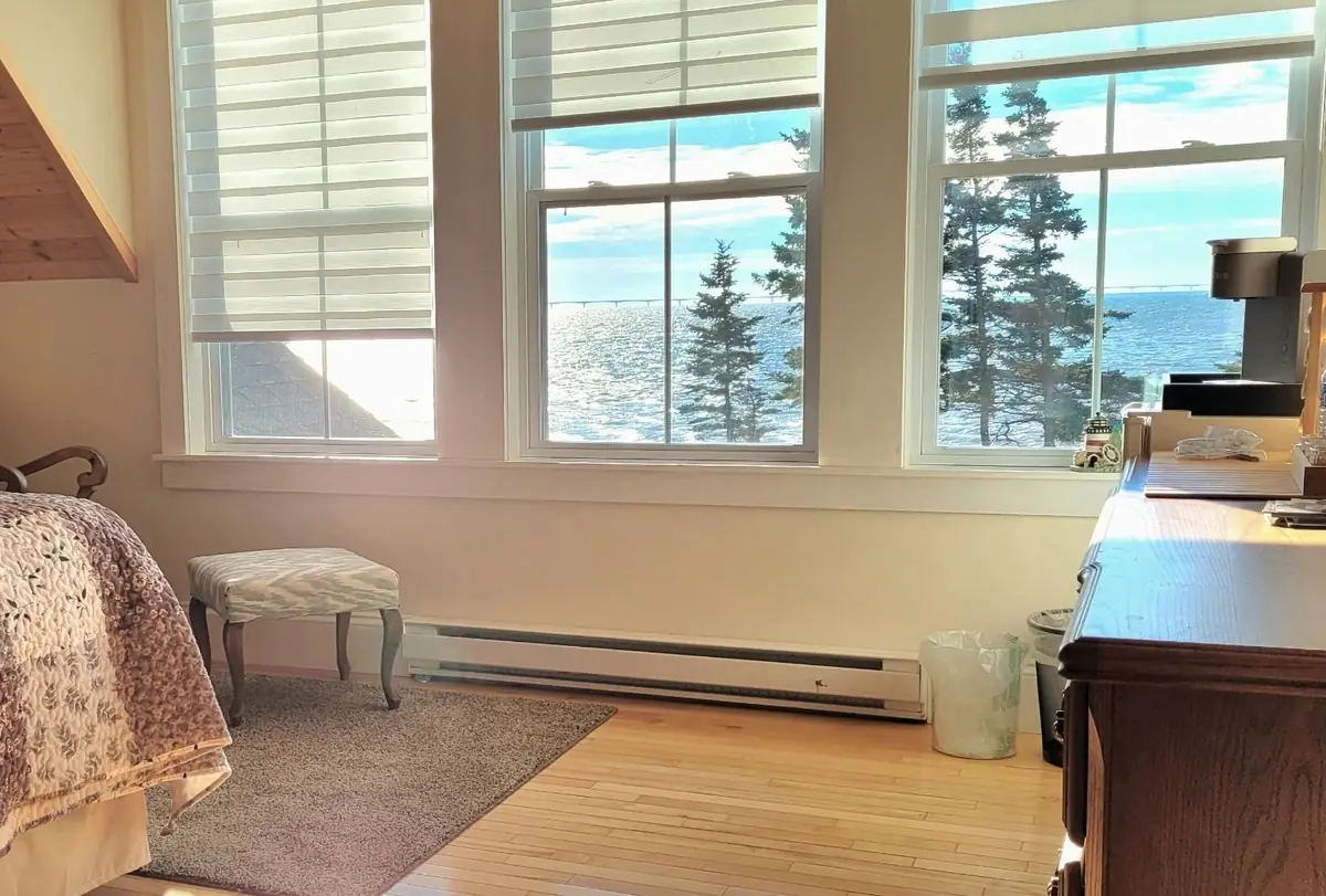 Guest bedroom with a sloped ceiling and a desk under the window