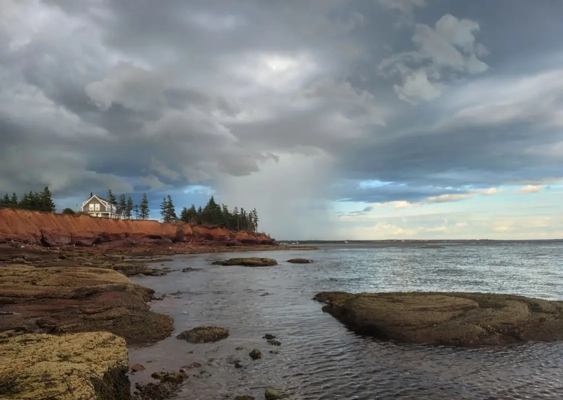 Rocky red shoreline under a summer sky, below the Knook